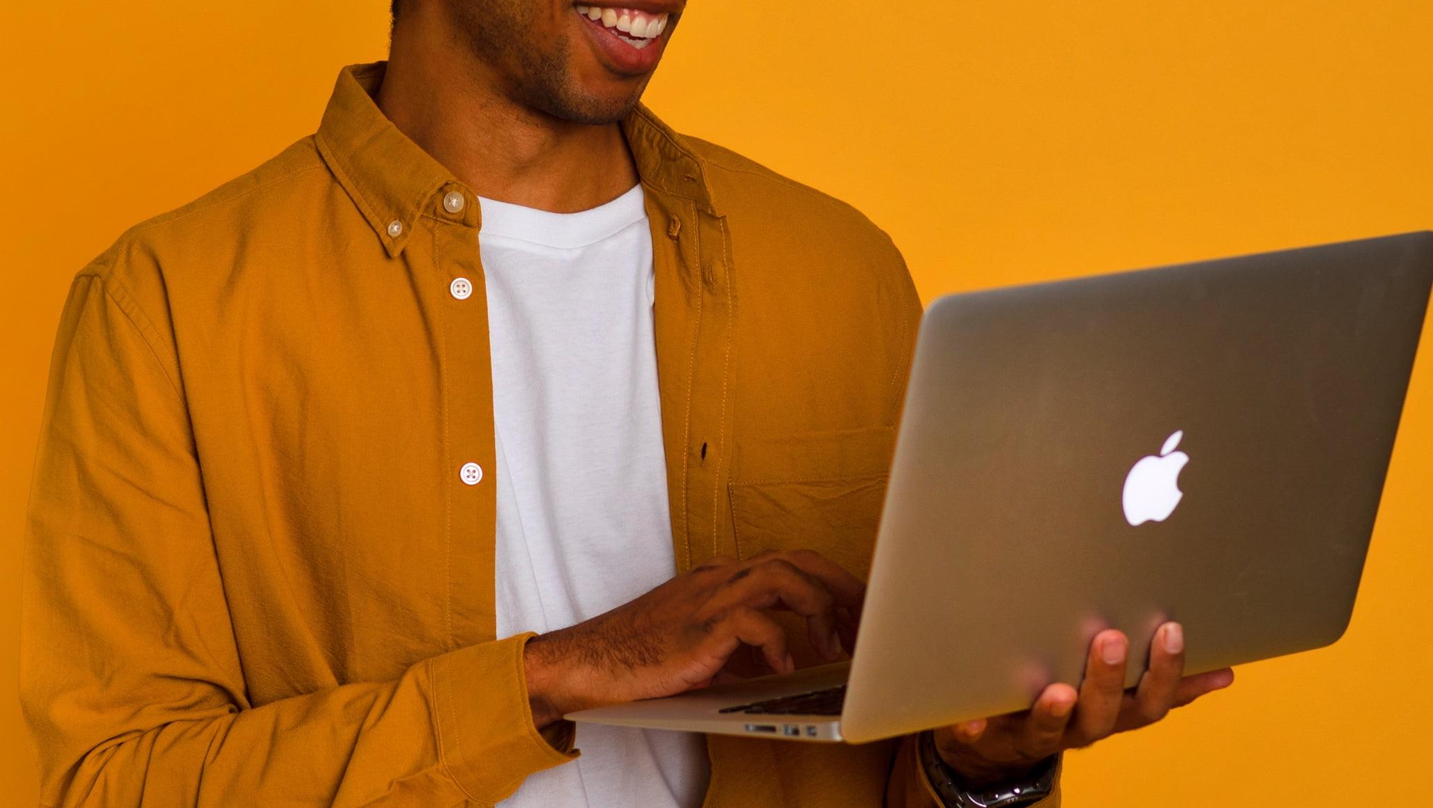 Mike Smiling and Holding MacBook