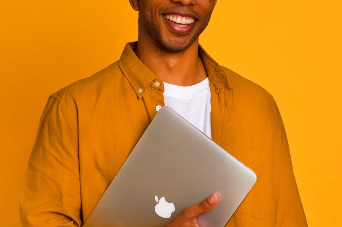 Mike Smiling with Macbook Across Chest