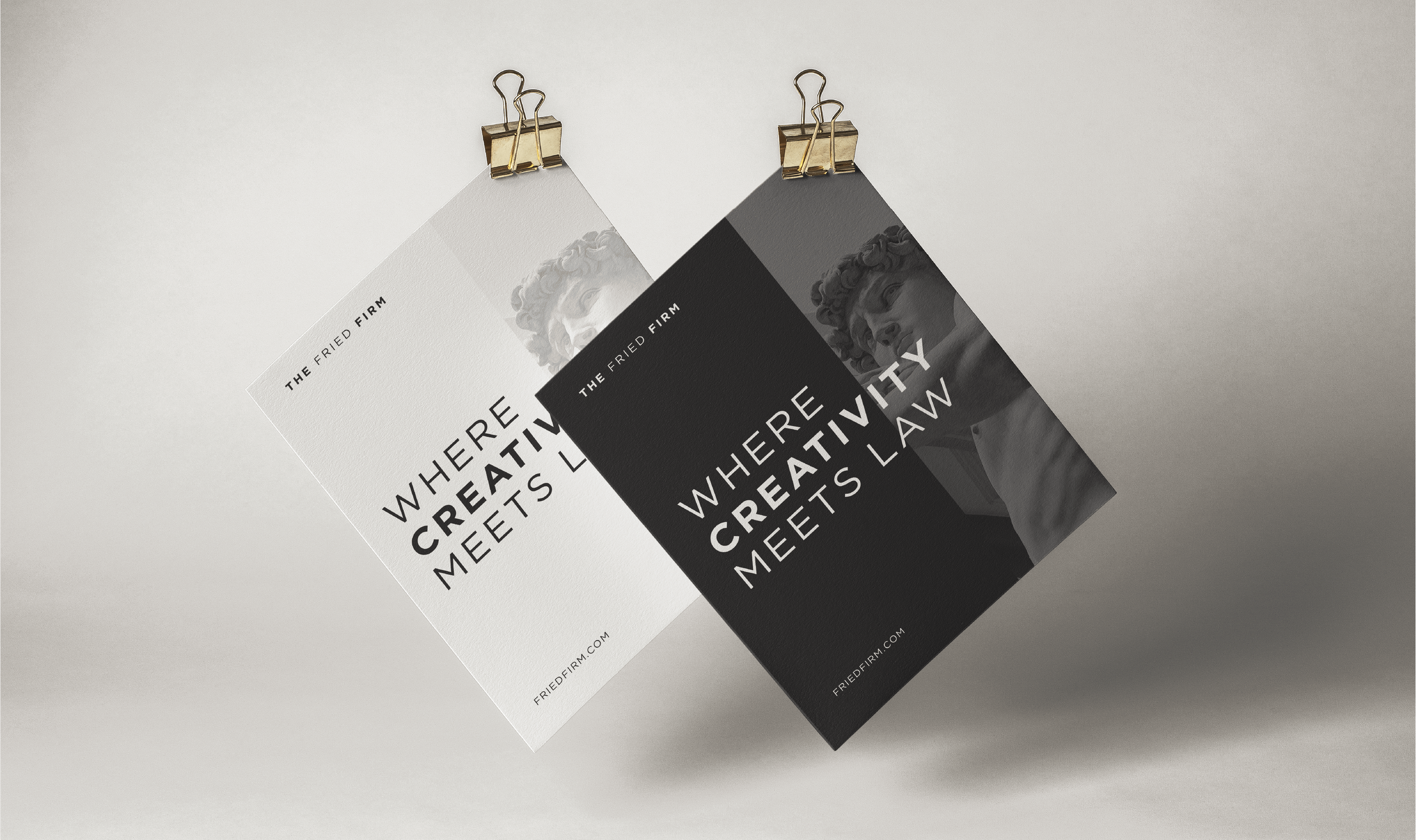 Two posters clipped and hanging side by side. The left is white, the right is black. Both read 