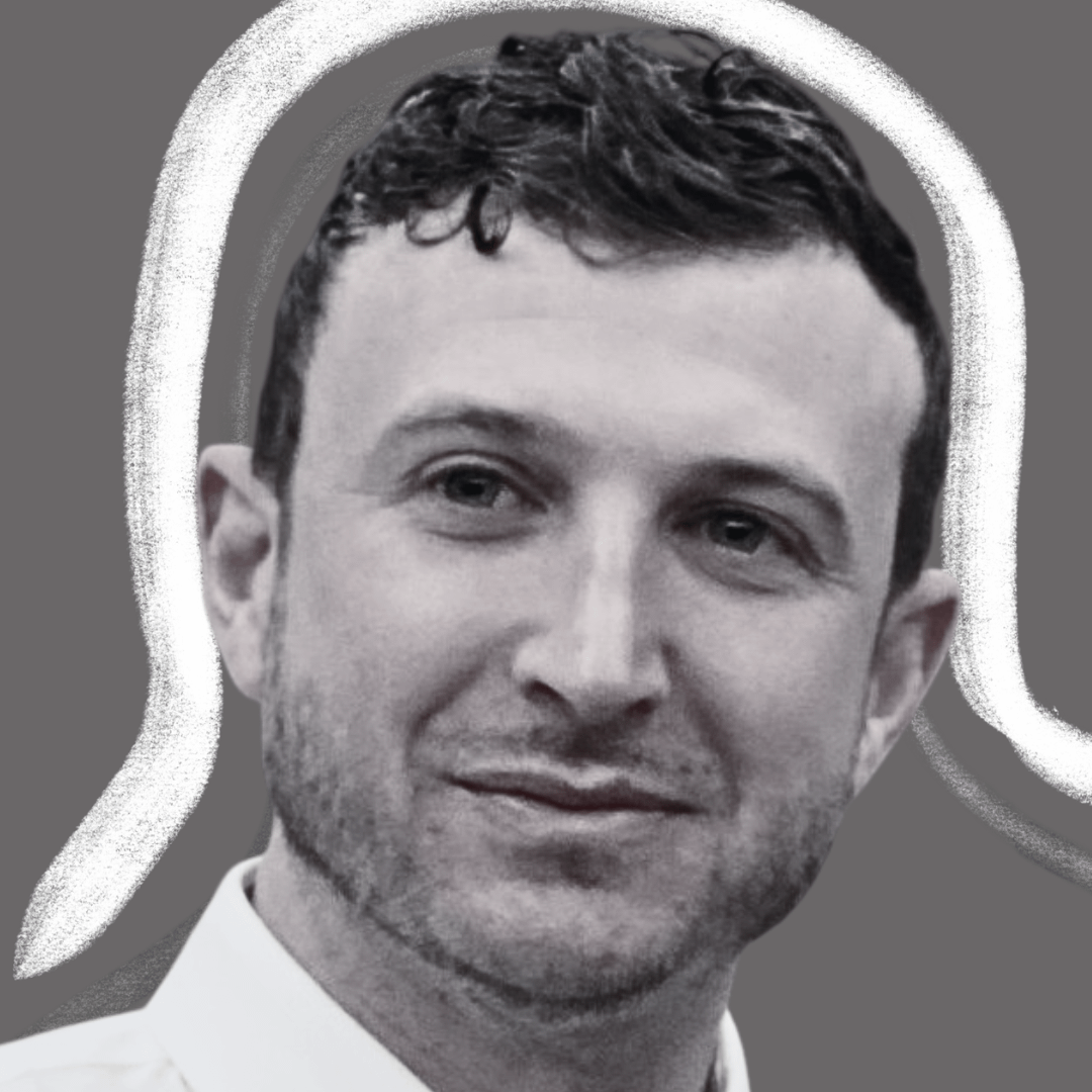 A man with short curly hair and a trimmed beard is shown in a grayscale portrait, with a white, hand-drawn outline resembling a conversation bubble around his head against a gray background.