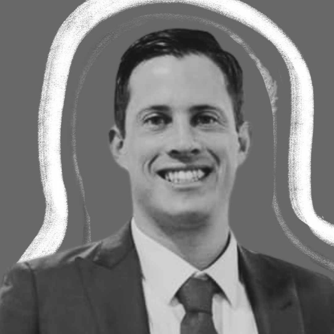 A man in a suit and tie smiles at the camera in a black-and-white photo, with a gray background and white sketch-like outlines around his silhouette.