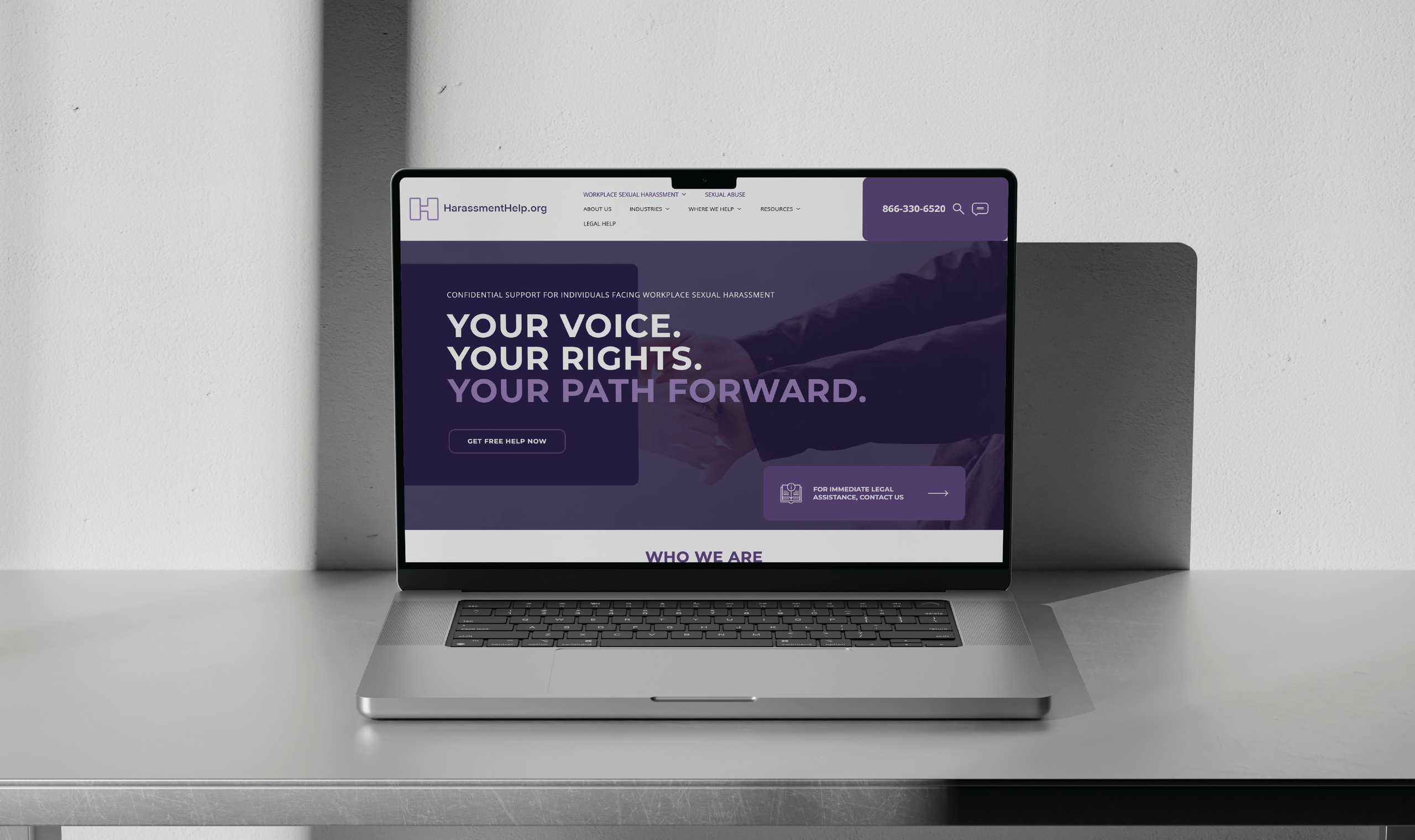 A laptop displays a website with the message: 