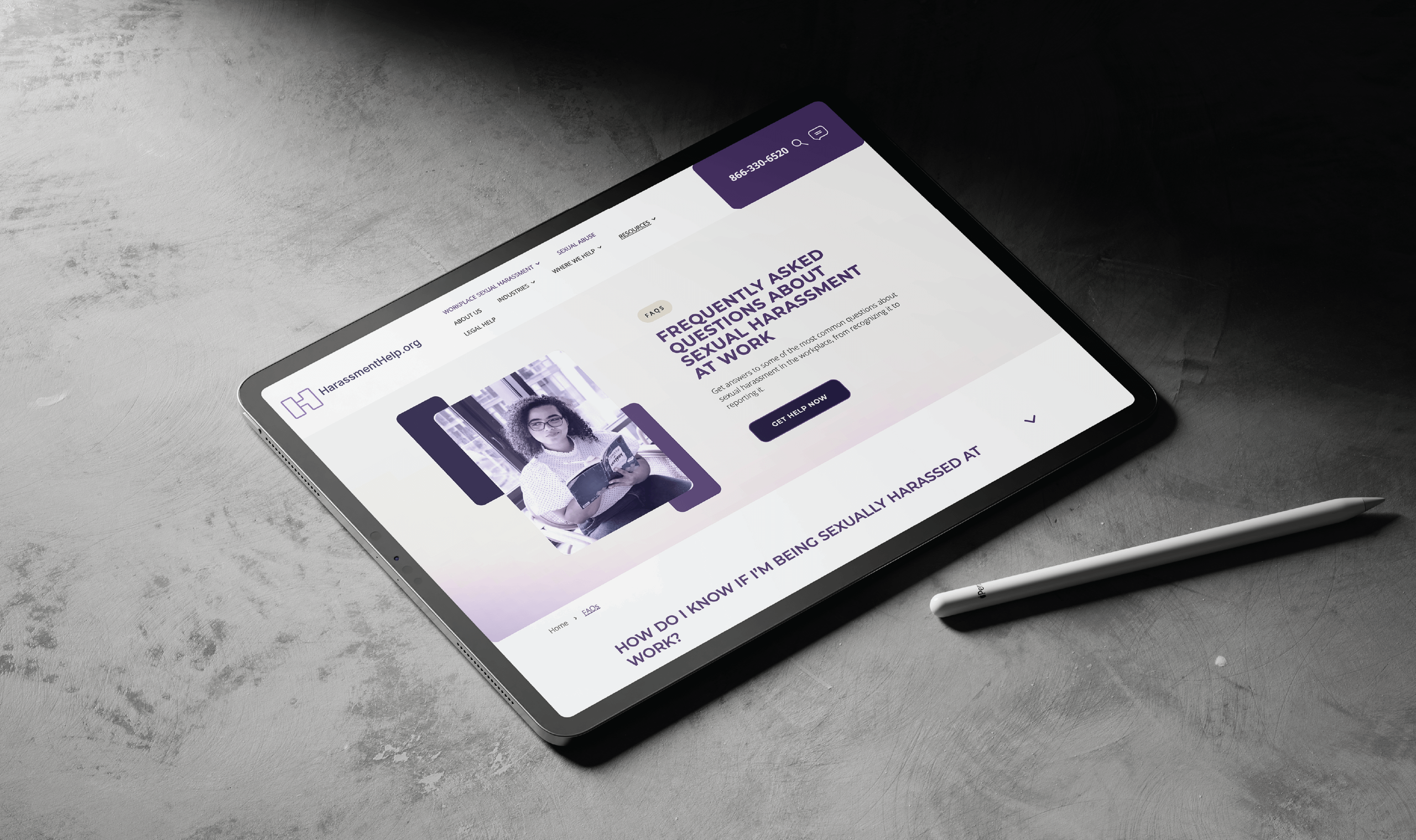 A tablet on a gray surface displays a website about sexual harassment at work, featuring a seated woman reading. A stylus lies beside the tablet.