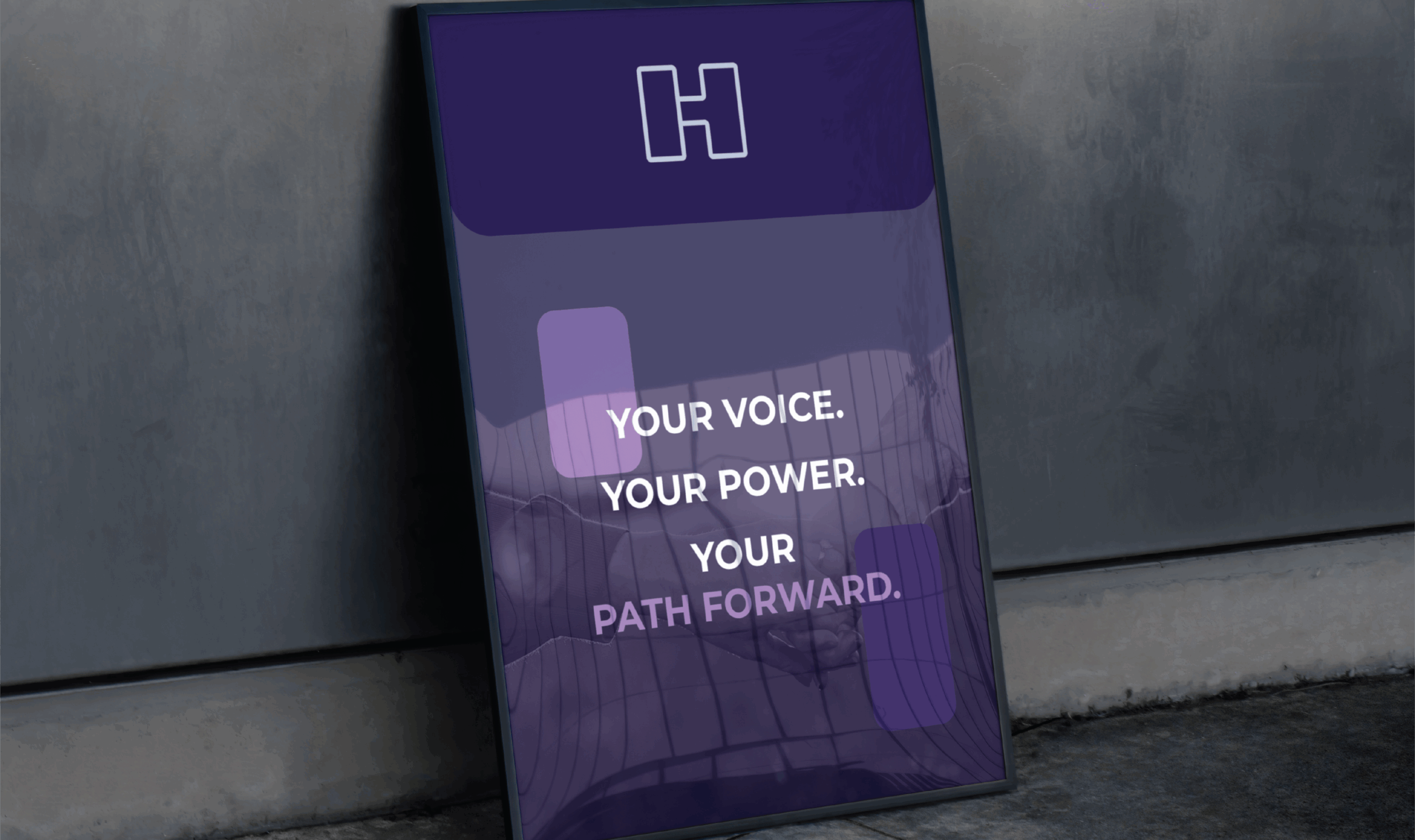 Framed poster leaning against a concrete wall with a purple background. It features the letter 