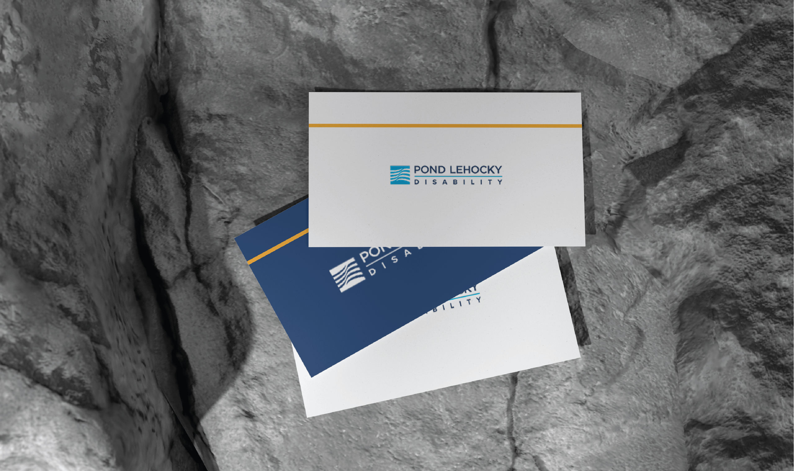 A stack of business cards for Pond Lehocky Disability rests on a rocky surface. The top card is white with blue and gold accents.