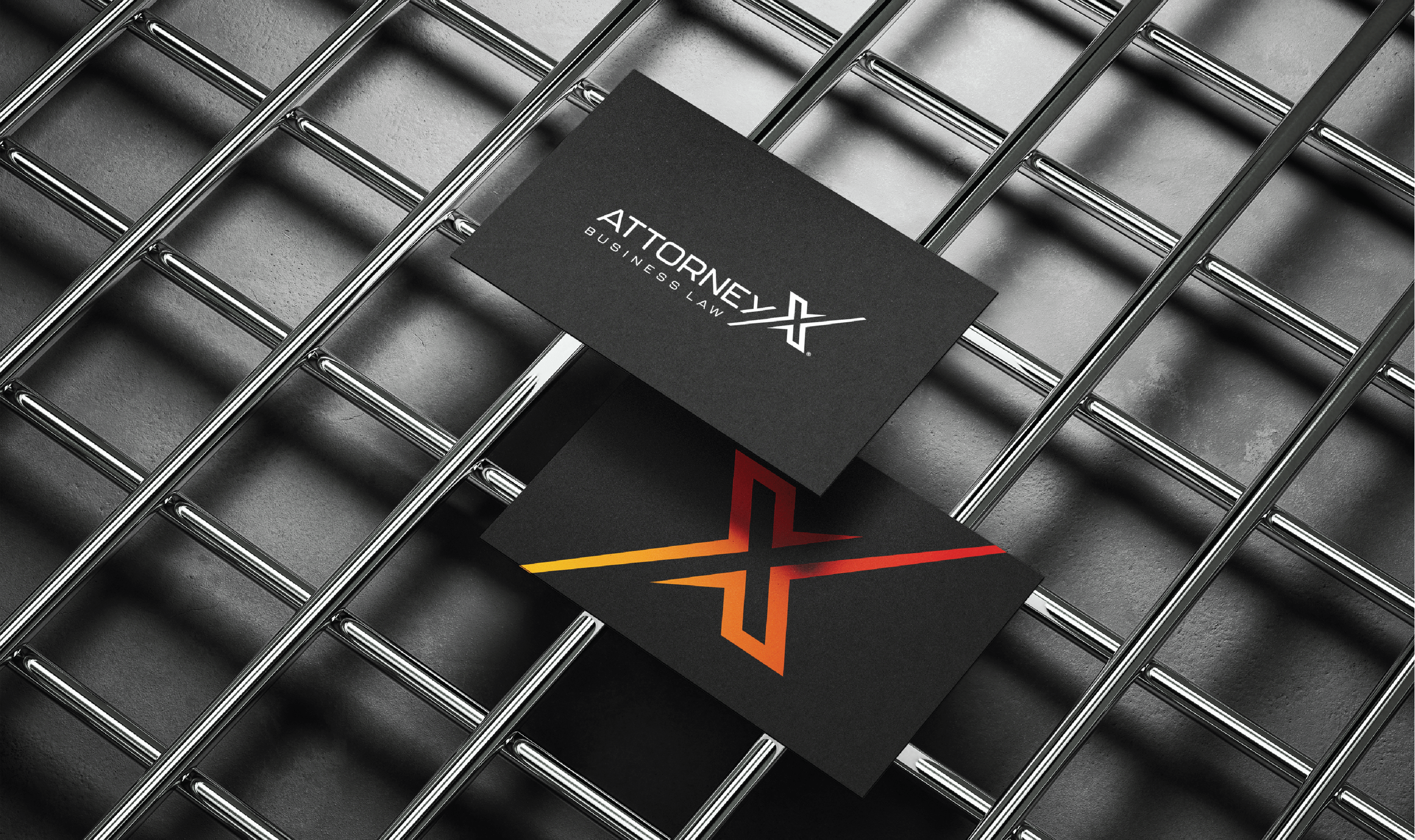 Two black business cards rest on a metal grid. One card displays 