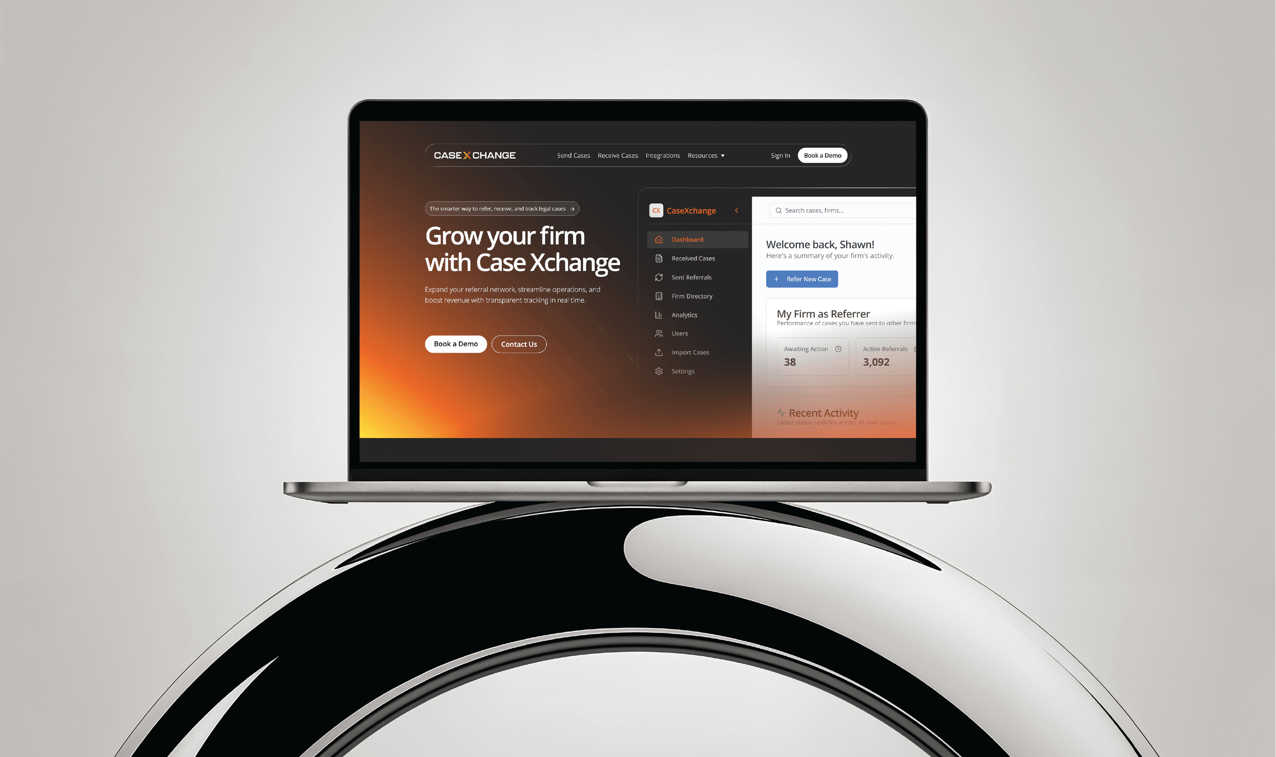 Laptop displaying the Case Xchange website with a dashboard interface and tagline “Grow your firm with Case Xchange,” shown against a light gray background with the laptop resting on a glossy, curved black-and-white surface.